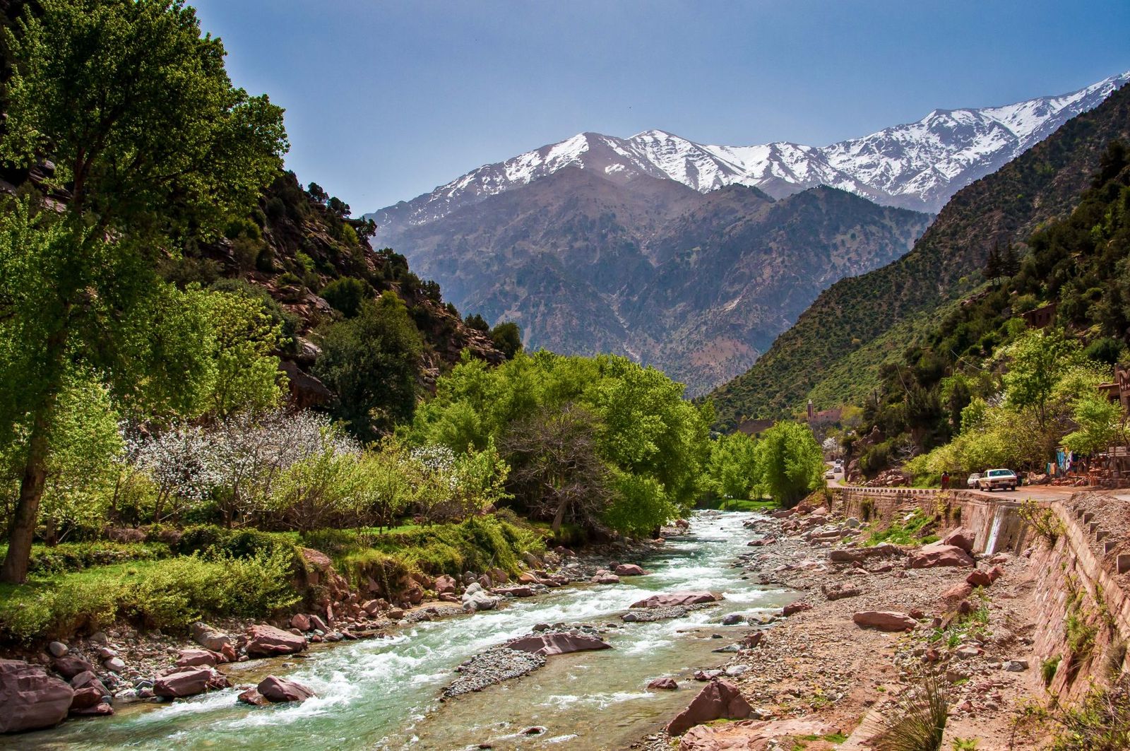 Ourika river and green valley below the snow-capped High Atlas